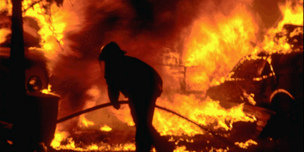 fire fighter silhouetted by fire