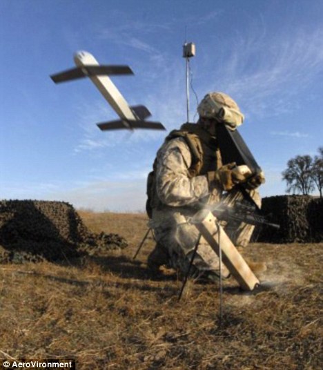 A soldier launches a 'kamikaze' drone and watches its live feed as it flies out of a tube.